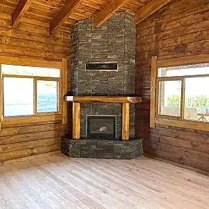 Rustik şömine modeli, doğal taş kaplama ve ahşap kütük detaylı ön görünüm