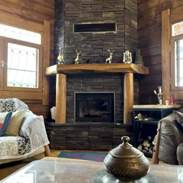 Rustik şömine modeli, iç mekânda kurulmuş halde doğal taş ve ahşap kombinasyonu