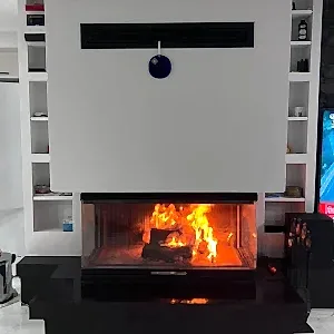 Modern şömine modelleri – siyah mermer tabanlı, üç camlı odunlu şömine